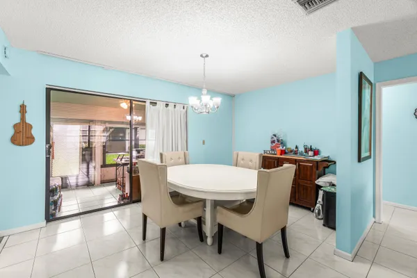 a dining room with furniture a chandelier and window