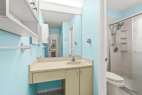 a bathroom with a sink a toilet and shower