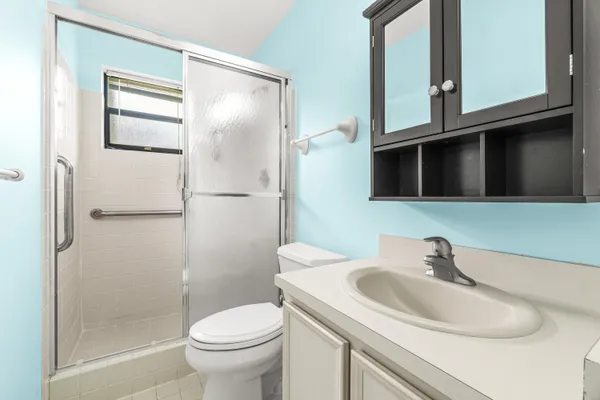 a bathroom with a sink a toilet and shower