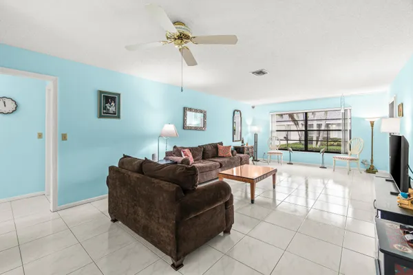 a living room with furniture a flat screen tv and a floor to ceiling window