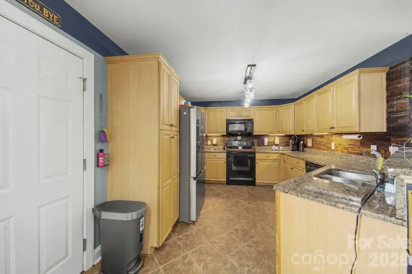 a kitchen with stainless steel appliances granite countertop a stove a sink and a microwave