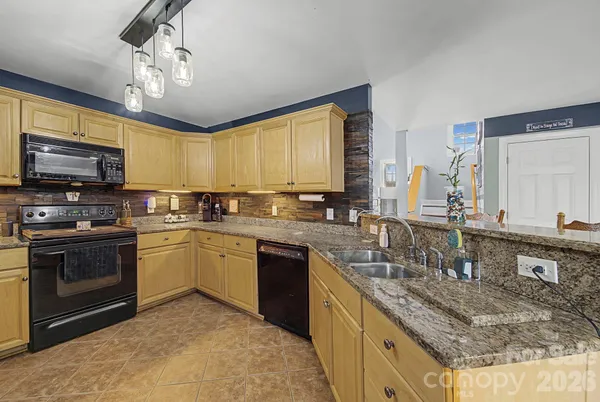 a kitchen with stainless steel appliances granite countertop a refrigerator stove microwave and sink