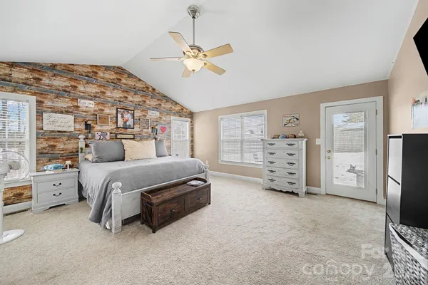 a bedroom with a bed and a flat tv screen on dresser