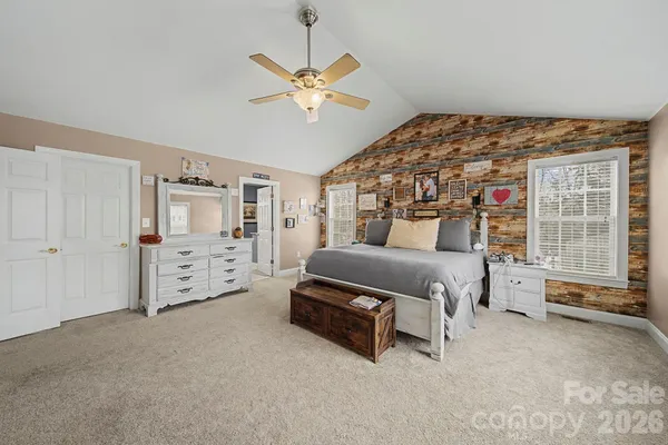 a spacious bedroom with a bed and a flat screen tv