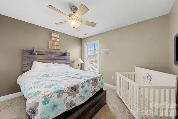 a bedroom with a large bed and a chandelier