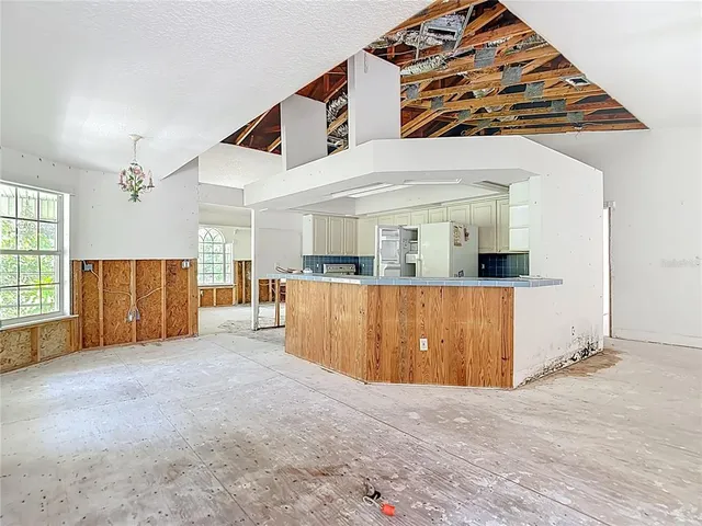 a view of a house with a yard plants and large tree