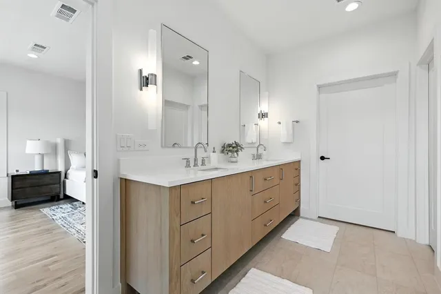 a spacious bathroom with double vanity sink a mirror and a shower