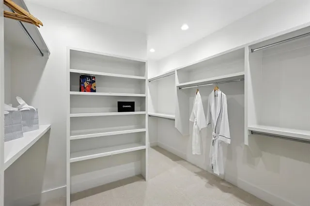 a view of walk in closet with clothes and shoes