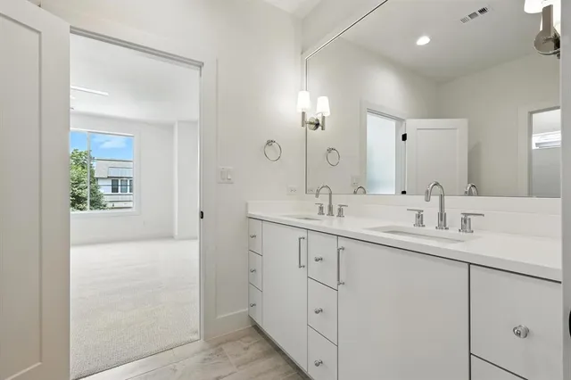 a bathroom with double sink and a mirror