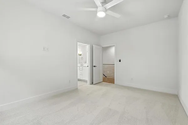 an empty room with closet and a ceiling fan