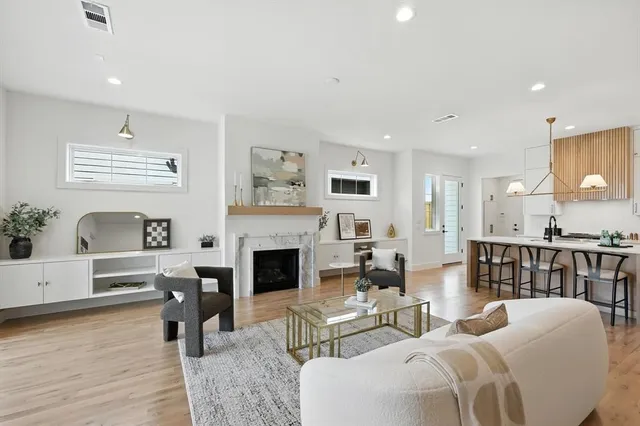 a living room with furniture a fireplace and a kitchen view