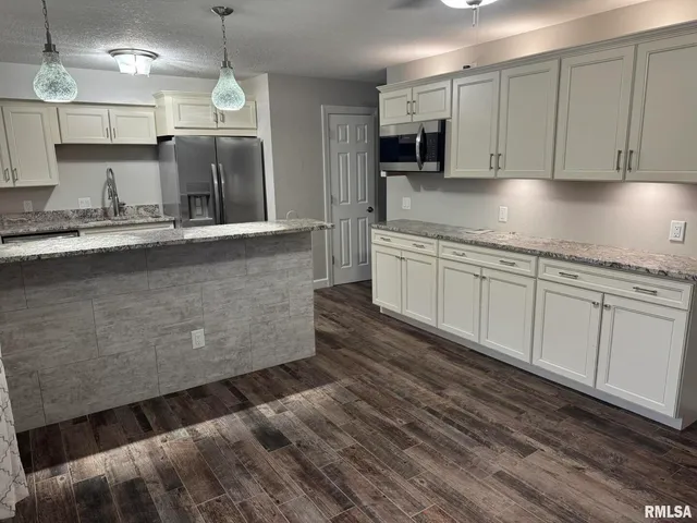 a kitchen with stainless steel appliances granite countertop a sink a stove and a refrigerator