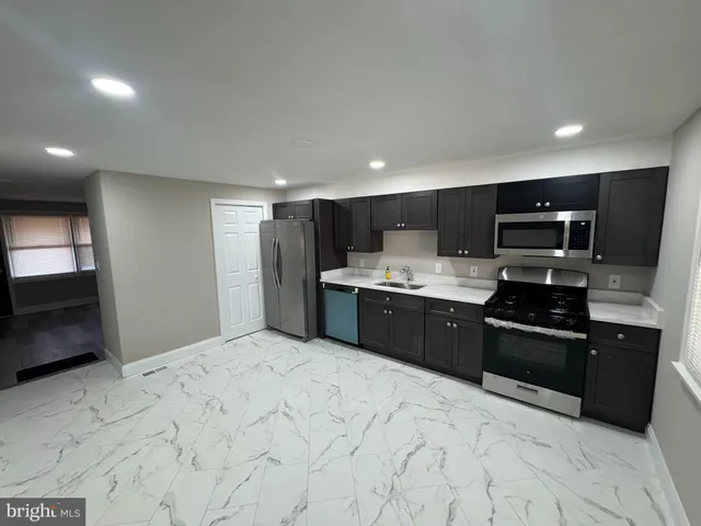 a large kitchen with stainless steel appliances kitchen island granite countertop a sink and cabinets