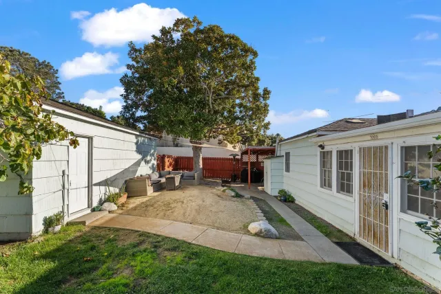 a view of a house with backyard and sitting area