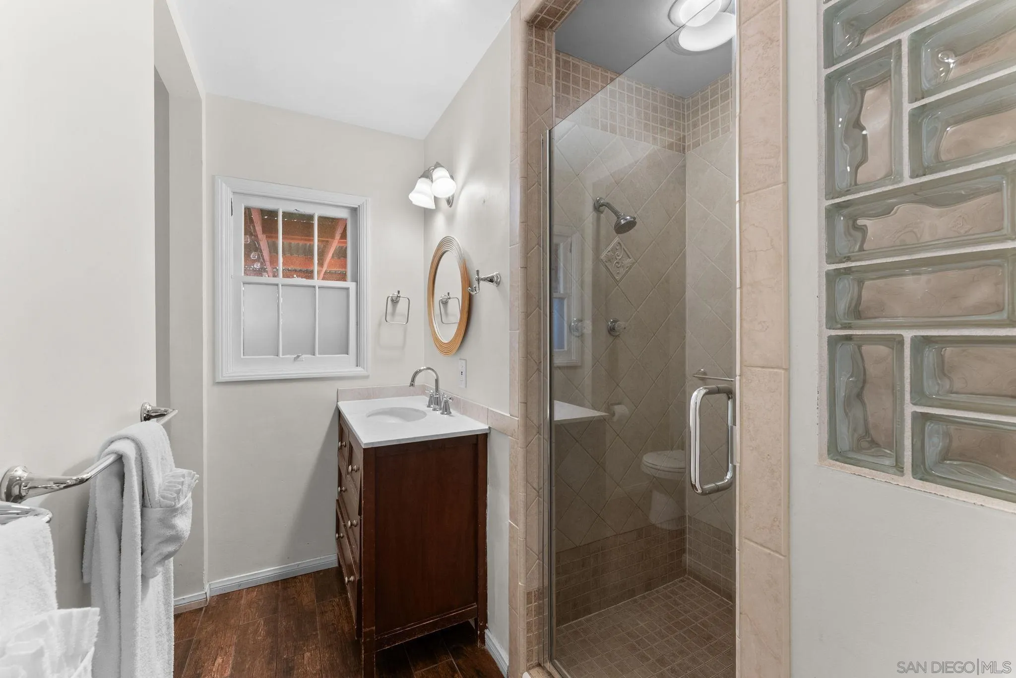 7005 Draper Avenue La Jolla, CA 92037 - Photo 20 of 26 a bathroom with a double vanity sink mirror and shower