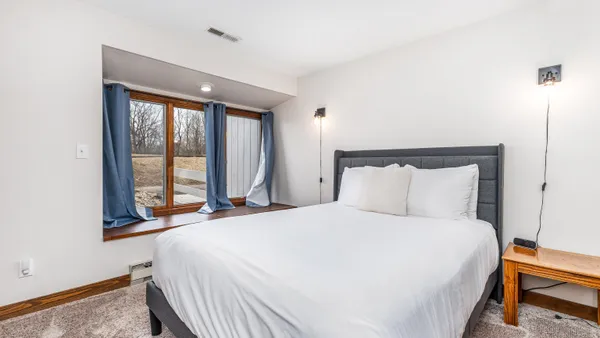 a bed sitting in a bedroom next to a window