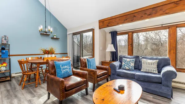 a living room with furniture and a floor to ceiling window