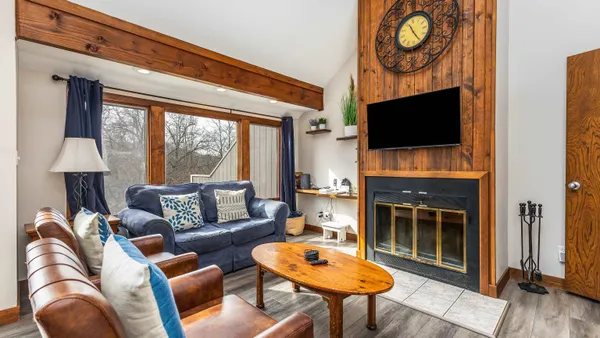 a living room with furniture a fireplace and a flat screen tv