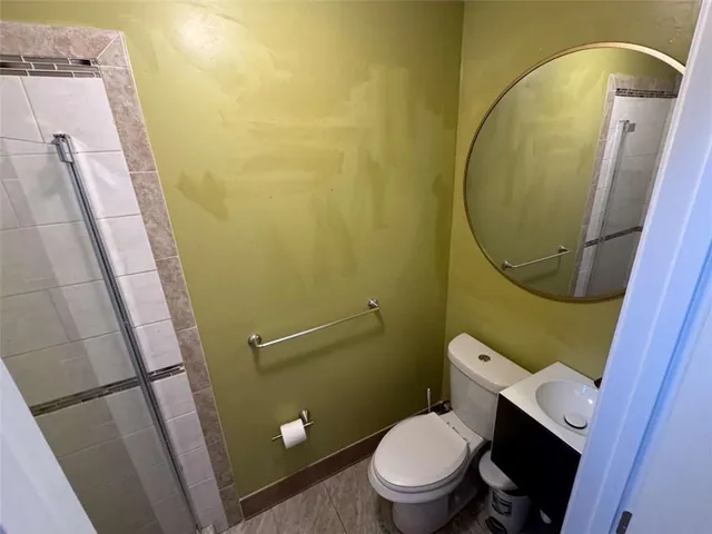 a white toilet sitting next to a sink and vanity