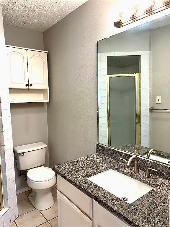 7809 Topawa Cove, Unit B Austin, TX 78729 - Photo 11 of 14 a bathroom with a granite countertop toilet sink and mirror