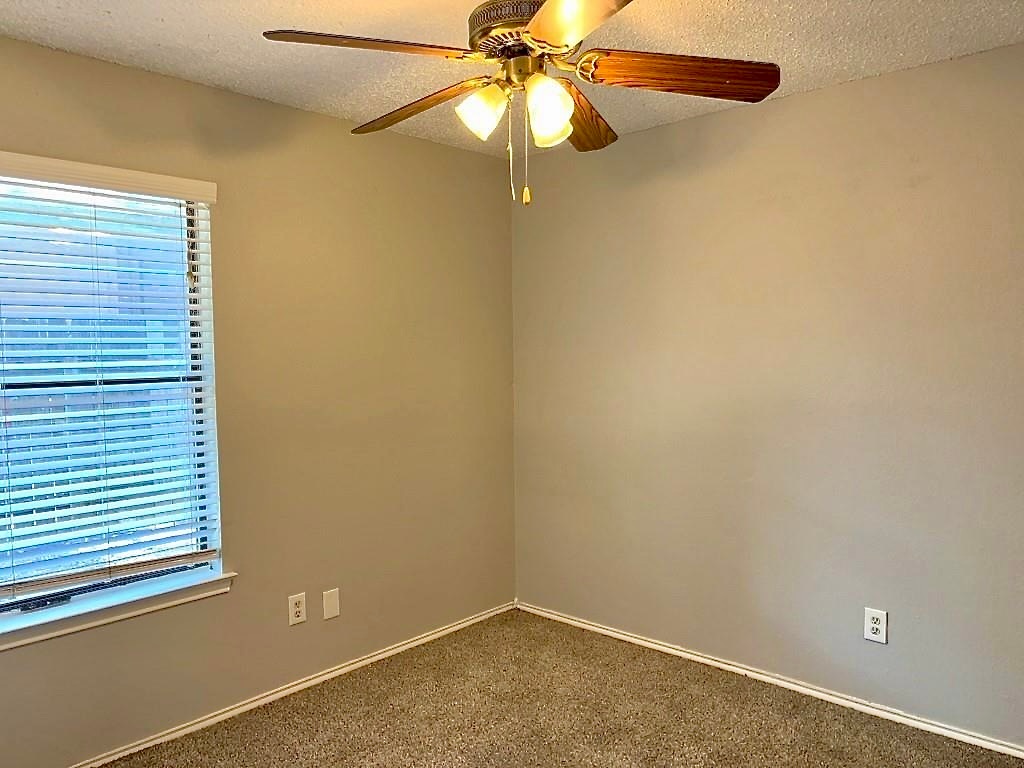 7809 Topawa Cove, Unit B Austin, TX 78729 - Photo 12 of 14 an empty room with a window and a fan