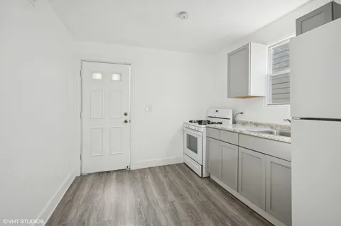 a view of a kitchen with sink cabinets and wooden floor