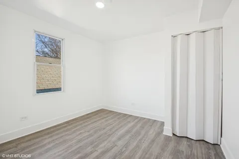 a view of a room with wooden floor and a window