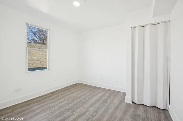 a view of a room with wooden floor and a window