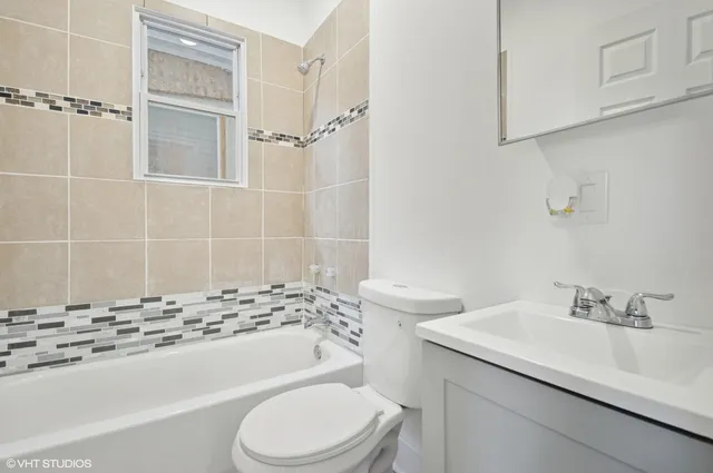 a bathroom with a sink toilet vanity and shower