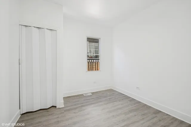 a view of a room with wooden floor and a window