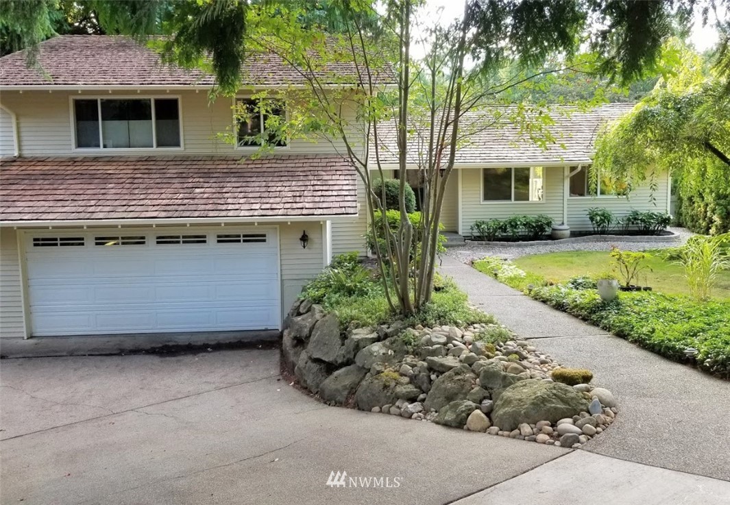 17023 154th Place Southeast Renton, WA 98058 - Photo 1 of 24 a front view of a house with a garden and trees