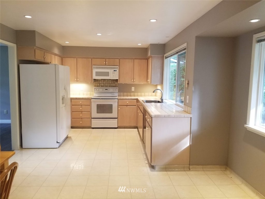 17023 154th Place Southeast Renton, WA 98058 - Photo 15 of 24 a kitchen with stainless steel appliances granite countertop a refrigerator sink and cabinets