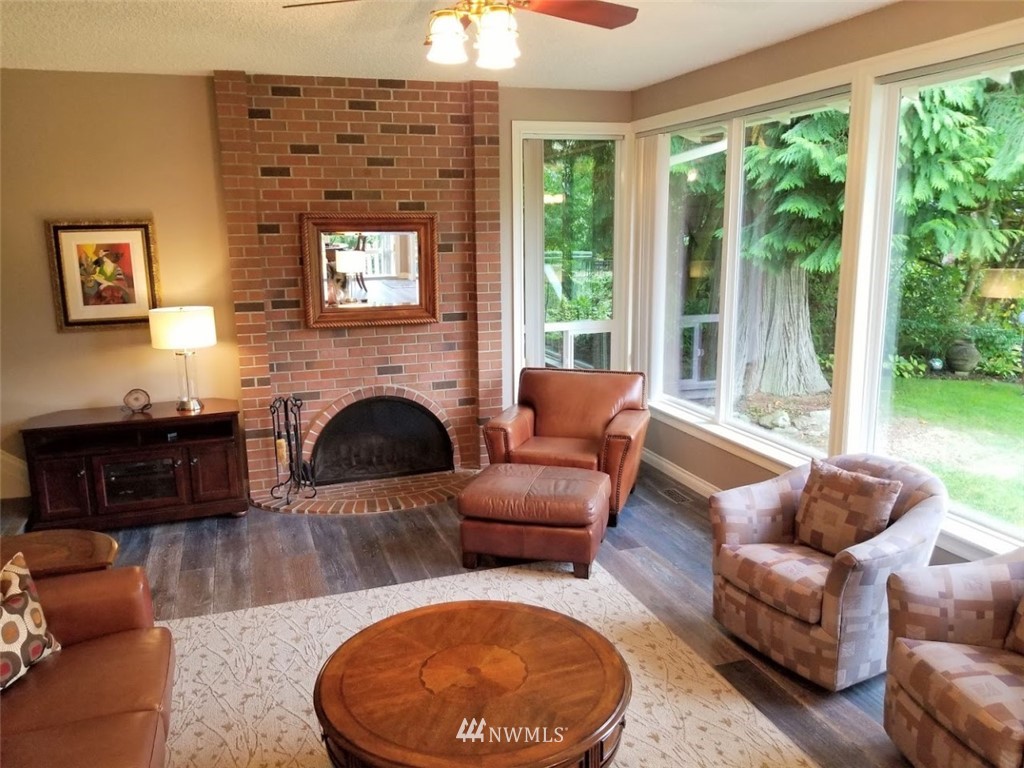 17023 154th Place Southeast Renton, WA 98058 - Photo 3 of 24 a living room with furniture a fireplace and a floor to ceiling window