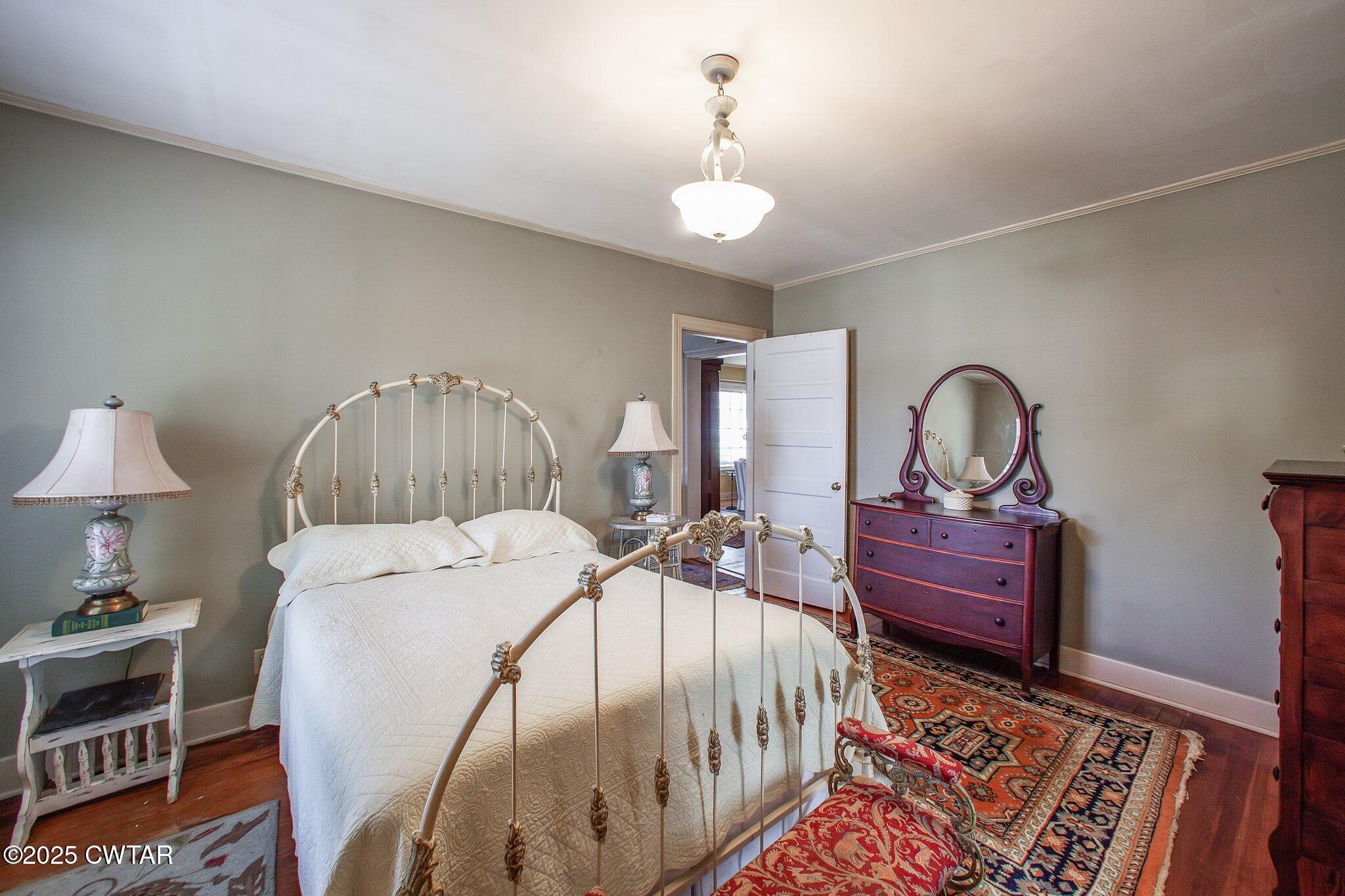 302 Walnut Street Jackson, TN 38301 - Photo 17 of 38 a bed room with a bed and a chandelier