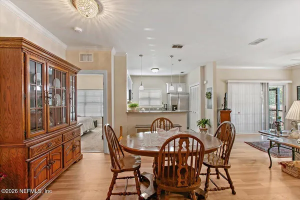 a dining room with furniture a chandelier and wooden floor