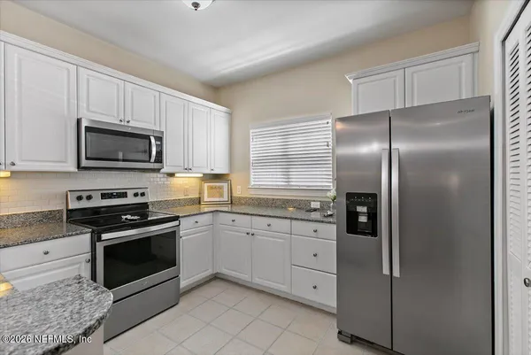 a kitchen with cabinets stainless steel appliances and sink