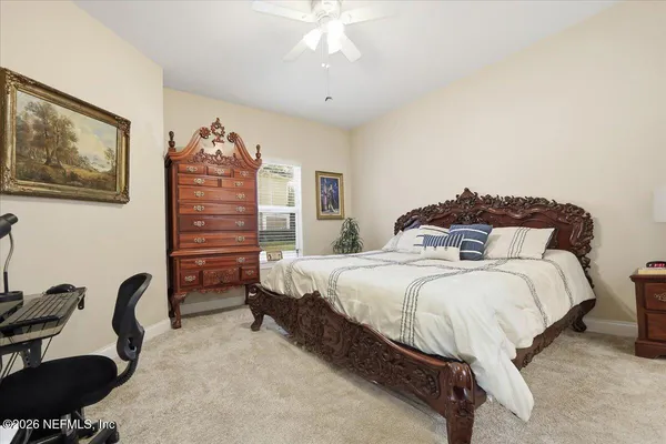 a spacious bedroom with a bed a desk and chair
