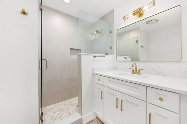 a bathroom with a shower sink and mirror