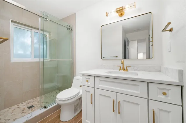 a bathroom with a sink a toilet and shower