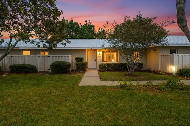 a view of a house with backyard and a tree