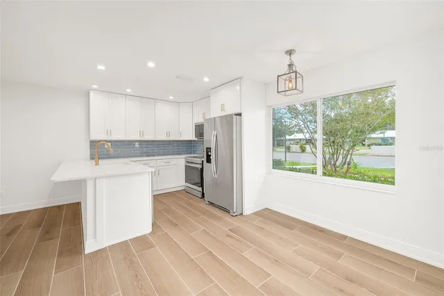 a kitchen with a refrigerator a sink and cabinets