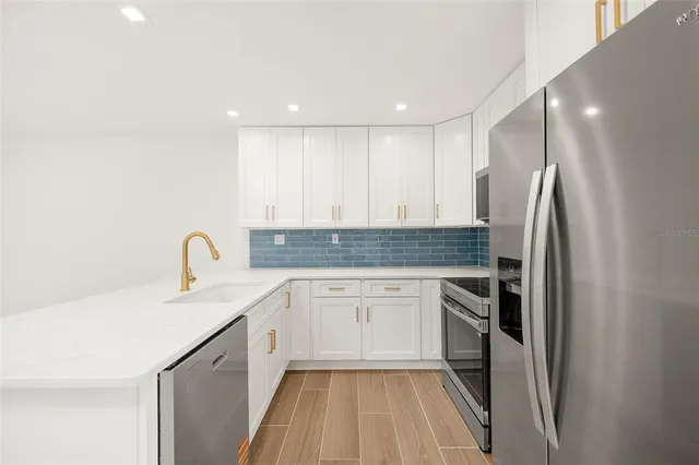 a kitchen with a sink appliances and cabinets