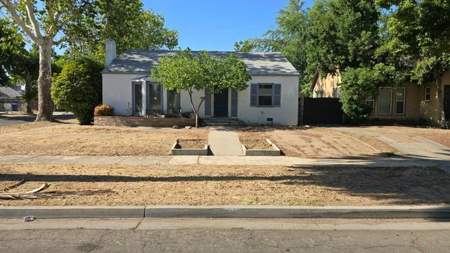 a wooden bench sitting in front of a house