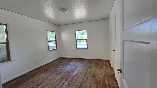 wooden floor in an empty room with a window