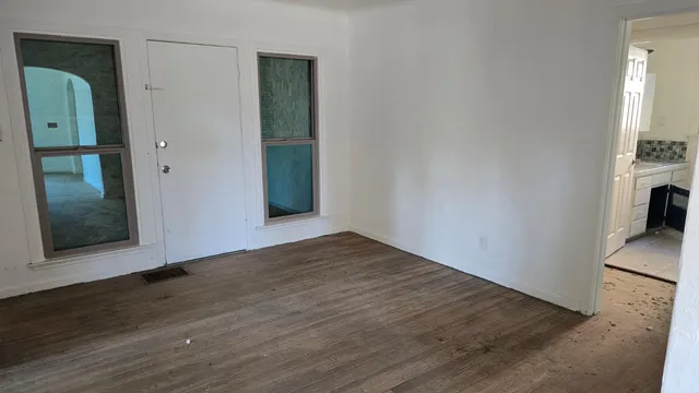 wooden floor in an empty room with a window