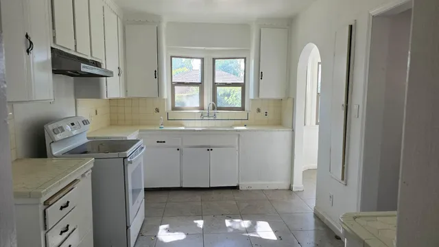 a kitchen with a sink cabinets and a window