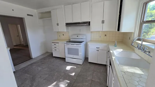 a kitchen with a stove sink and a refrigerator