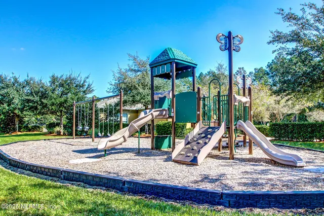 a kitchen with stainless steel appliances kitchen island granite countertop a dining table chairs and a refrigerator