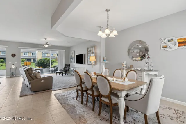 a living room with furniture and a large window with kitchen view