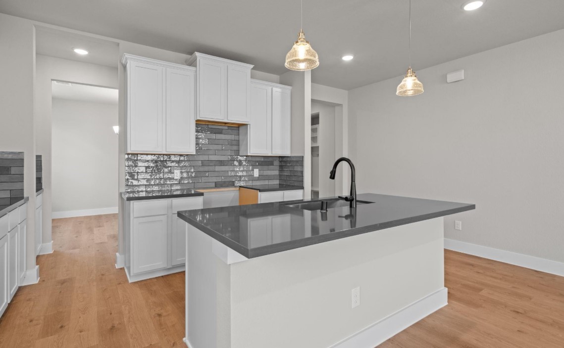 325 Gambels Quail Road Hempstead, TX 77445 - Photo 4 of 21 a kitchen with kitchen island granite countertop a sink and wooden floors
